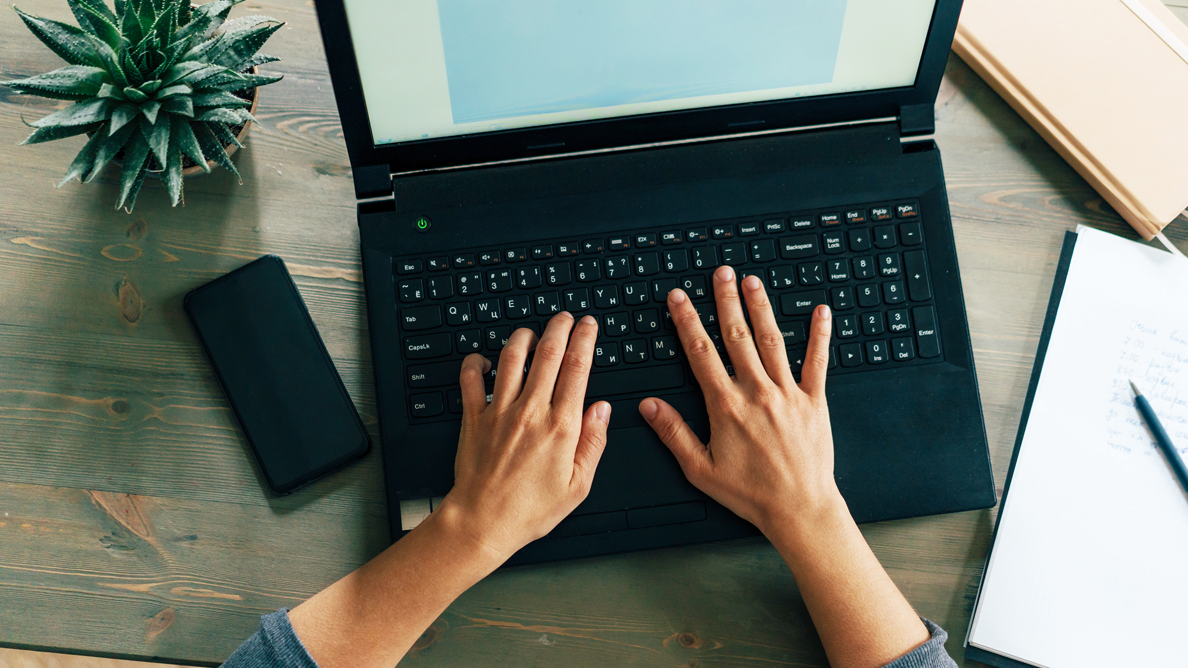Thumbnail Hands on a laptop keyboard at cozy workplace